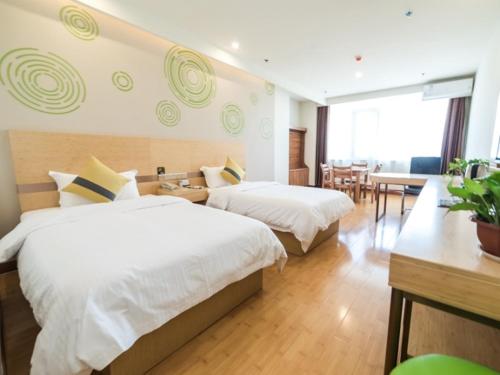 a hotel room with two beds and a table at GreenTree Inn Binzhou Yangxin County Bus Station Lubei Da Market Business Hotel in Binzhou