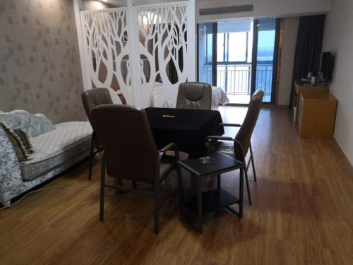 a room with a table and chairs and a bedroom at GreenTree Alliance ZheJiang Huzhou Changxing Zhebei Business Square Hotel in Chenjiaqiao