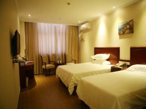 A bed or beds in a room at GreenTree Inn Xinjiang Tulufan North Xihuan Road Express Hotel