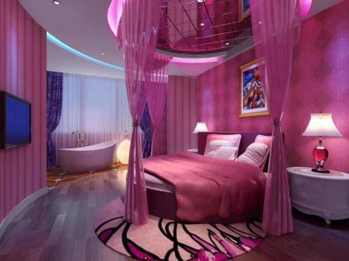 a pink bedroom with a bed and a bath tub at Shell Lianyungang Donghai County Crystal City Shichen Road Hotel in Donghai