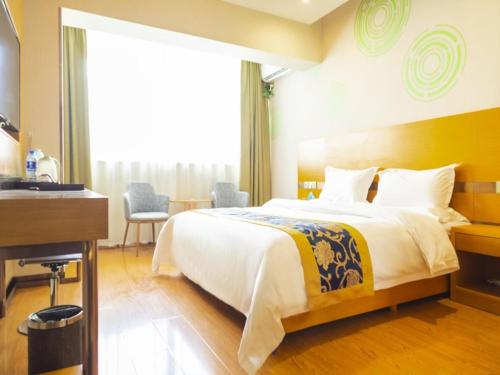 a hotel room with a bed and a desk and a sink at GreenTree Inn Xi'an Ming City Wall Northwest Dafengqing Road Business Hotel in Xi'an
