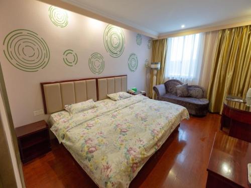 a bedroom with a large bed and a couch at GreenTree Inn Jiangsu ZhenJiang Jurong New Bus Station Express Hotel in Jurong
