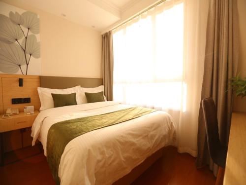 a bedroom with a large bed and a window at GreenTree Inn Hebei Langfang Development Zone Convention and Exhibition Centre Business Hotel in Langfang