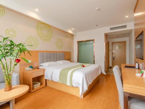 a bedroom with a large bed and a desk and a table at GreenTree Inn Hefei Shushan District Binhu Qiancheng Business Hotel in Hefei