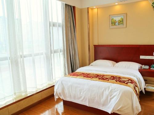 a bedroom with a large bed and a large window at GreenTree Inn Wuxi New District Hongshan Town Commercial Square Shell Hotel in Dongkunqiao