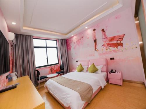 a bedroom with a large bed and a painting on the wall at GreenTree Inn Suzhou Zhangjiagang City Jingang Town Express Hotel in Zhangjiagang