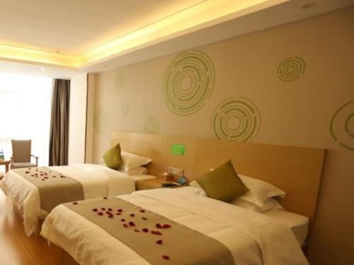 a hotel room with two beds with roses on them at GreenTree Inn Suzhou Yongqiao District Fuxiao Avenue Hotel in Suzhou