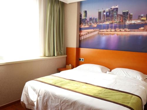 a bedroom with a bed with a large painting on the wall at Shell Rizhao Donggang District Bus station Hotel in Rizhao
