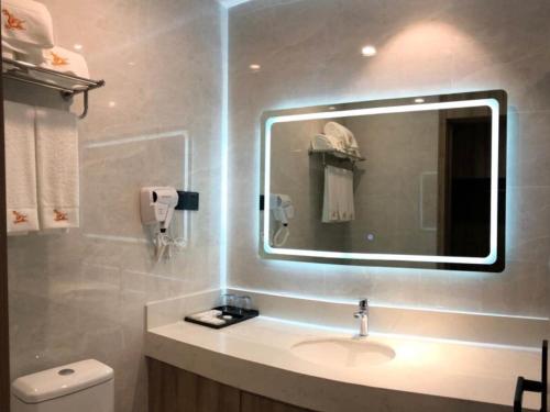 a bathroom with a sink and a mirror at GreenTree Eastern Huai'an Railway Station Mandu Plaza Hotel in Huai'an