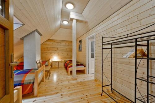 a room with wooden walls and a bedroom with bunk beds at Saulės Slėnis in Plateliai