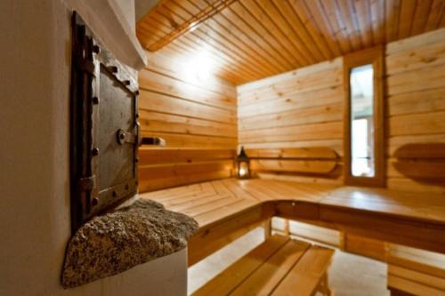 a sauna with a bench in a wooden room at Saulės Slėnis in Plateliai