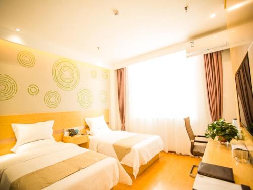 a hotel room with two beds and a window at GreenTree Inn Jinzhong Yuci Old Town Express Hotel in Jinzhong