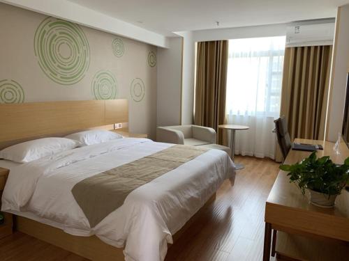 um quarto de hotel com uma cama grande e uma janela em GreenTree Inn Taizhou Taixing City Xuanbao Town Zhongyang Road Express Hotel em Yong'anzhou