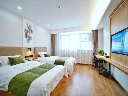 ein Hotelzimmer mit 2 Betten und einem Flachbild-TV in der Unterkunft GreenTree Inn Changzhou Xuebu Eastern Salt Lake City in Changzhou