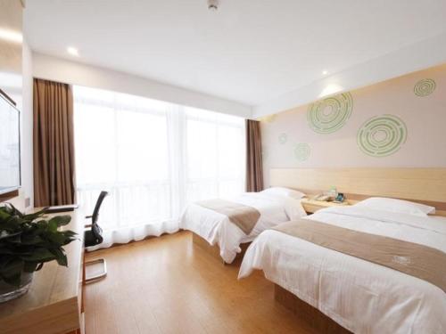 um quarto de hotel com duas camas e uma janela em GreenTree Inn Hefei Lujiang County Yihu West Road Chengxi No.4 Middle School Express Hotel em Lujiang