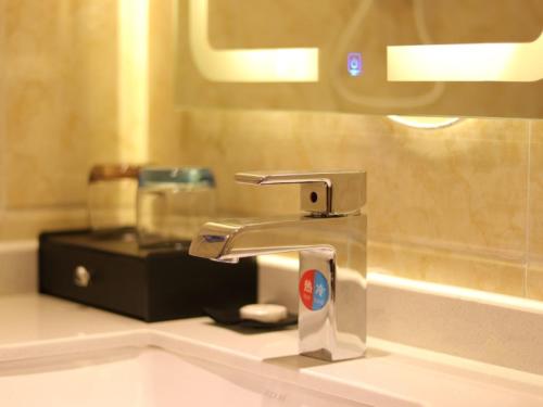 a bathroom sink with a faucet in a bathroom at Shell Rizhao Donggang District Bus station Hotel in Rizhao