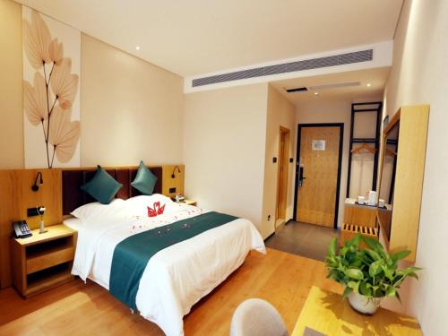 um quarto com uma cama grande num quarto em GreenTree Inn Zhengzhou Airport em Zhengzhou