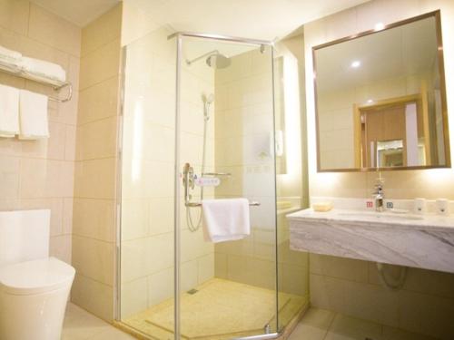 a bathroom with a shower and a toilet and a sink at GreenTree Inn Fuyang Linquan County Yiwu Trade City Express Hotel in Jinzhuang
