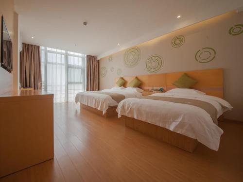a hotel room with two beds and a large window at GreenTree Inn Jiangsu Suzhou Gongyequan District Xinglong Street Express Hotel in Suzhou