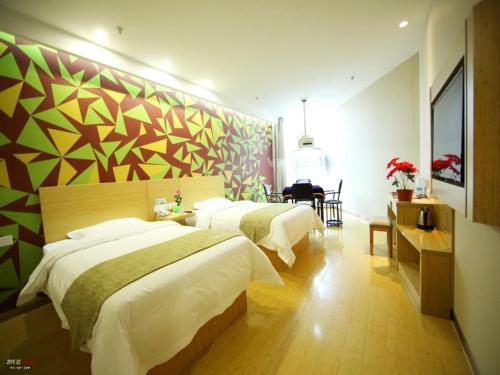 ein Schlafzimmer mit 2 Betten und einer farbenfrohen Wand in der Unterkunft VaticaWuxi Huishan District Western Shengan Road Baile Square Hotel in Wuxi