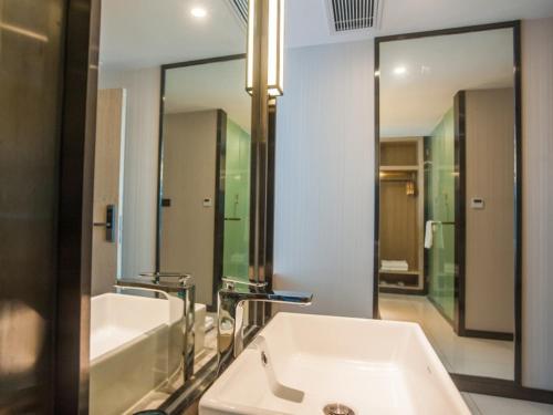 a bathroom with a white sink and a mirror at GreenTree EasternLianyungang Wanda Plaza Hotel in Lianyungang
