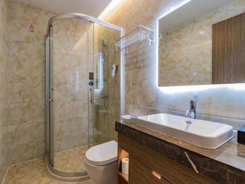 a bathroom with a sink and a shower and a toilet at Gya Jiaxing City Haiyan County Chang'an South Road Lishi Plaza Hotel in Jiaxing