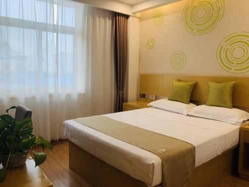 a bedroom with a large bed and a window at GreenTree Inn Tianjin Hedong District Tianjin Station Front Square Express Hotel in Tianjin