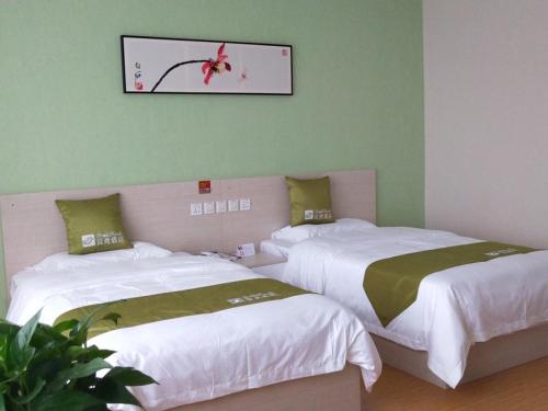 a room with two beds and a picture on the wall at Shell Chengde Xinglong County Banbishan Town Hotel in Xiabancheng