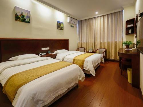 a hotel room with two beds and a desk at GreenTree Inn JiangSu ChangZhou LiYang TianMu Lake Avenue TaiGang (W) Road Business Hotel in Liyang