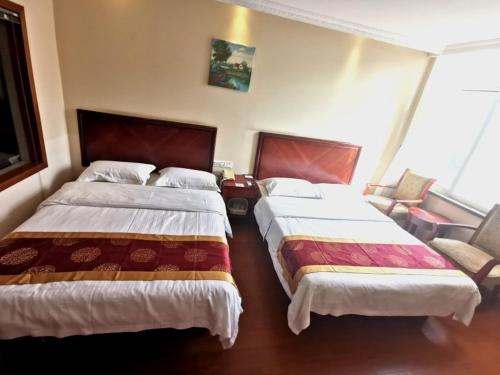 a hotel room with two beds and a chair at GreenTree Inn Jiangsu Huaian Economic Development Zone Hechang Road Business Hotel in Huai'an