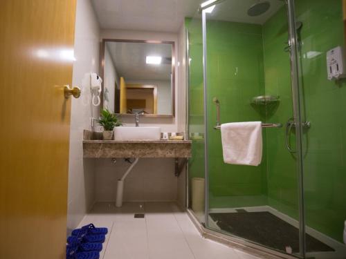 baño verde con lavabo y ducha en GreenTree Inn Hefei Feixi County South Jinzhai Road Jinyun International Business Hotel, en Sanshigang