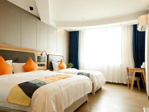 a hotel room with two beds and a window at Shell Tianshui Maiji District Erma Road Walking Street Hotel in Tianshui