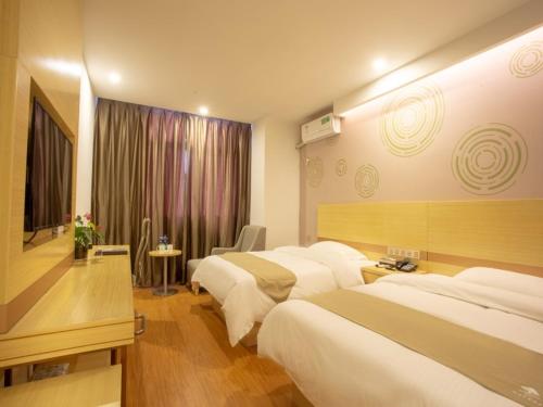 um quarto de hotel com três camas e uma janela em GreenTree Inn Chizhou Shitai County Government Affairs New District Business Hotel em Chizhou