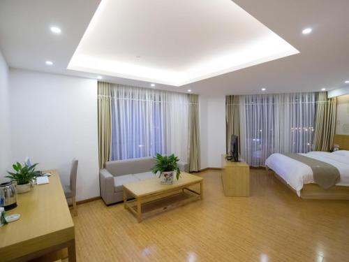 1 dormitorio con cama, sofá y mesa en GreenTree Inn Hefei Feixi County South Jinzhai Road Jinyun International Business Hotel, en Sanshigang