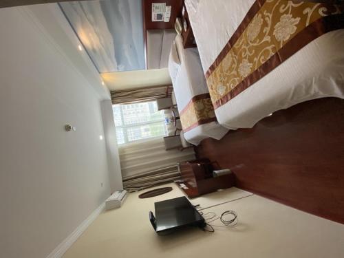 a bedroom with a bed and a laptop on the floor at GreenTree ShangHai JinShan Wanda Plaza Longxiang Road Express Hotel in Jinshan