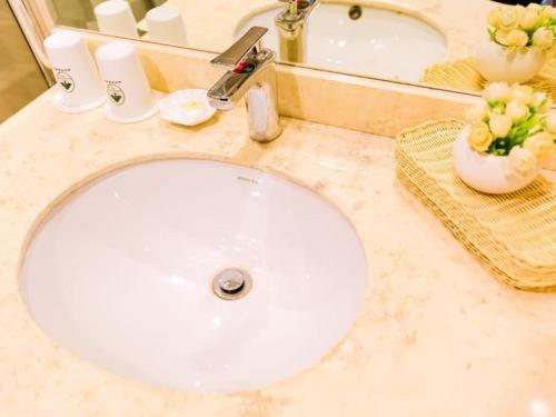 a bathroom counter with a white sink and a mirror at GreenTree Inn ShangHai JiaDing the South of F1 Circuit FangTai Hardware Market Express Hotel in Jiading