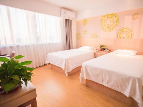 Cette chambre comprend 2 lits et une fenêtre. dans l'établissement GreenTree Inn Yangzhou Jiangdu Xiaoji Town South Zhongxing Road Express Hotel, à Xiaoji