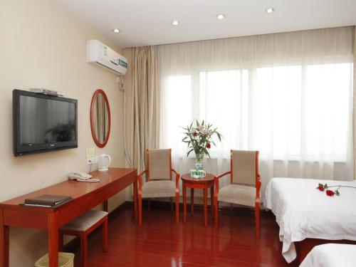 a hotel room with a desk and a bed at GreenTree Inn Rizhao West Station Suning Plaza in Rizhao