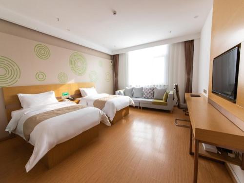 a hotel room with two beds and a flat screen tv at GreenTree Inn Baoding City Cangzhou Guanyun West Road Business Hotel in Zhuozhou
