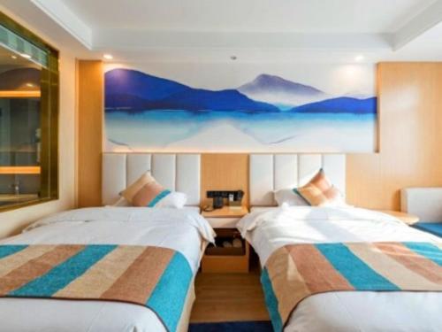 duas camas num quarto com um quadro na parede em VX Xuzhou Gulou District Yangshan Road Hotel em Xuzhou