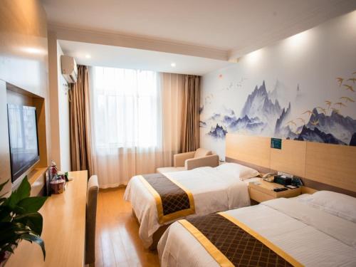 a hotel room with two beds and a tv at GreenTree Inn Anhui Hefei Wuhu Road Wanda Plaza Express Hotel in Hefei