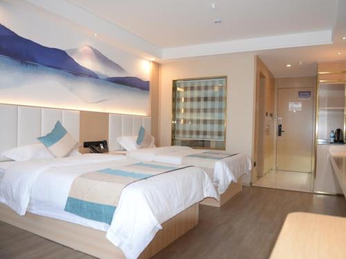 - une grande chambre avec 2 lits et une grande fenêtre dans l'établissement VX Xuzhou Gulou District Yangshan Road Hotel, à Xuzhou