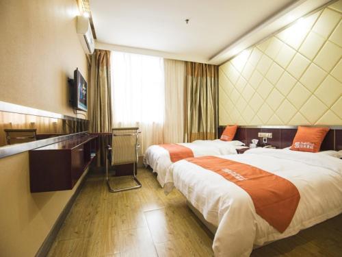 Habitación de hotel con 2 camas y TV en Shell Dingxi County Minzhou East Road Hotel, en Min