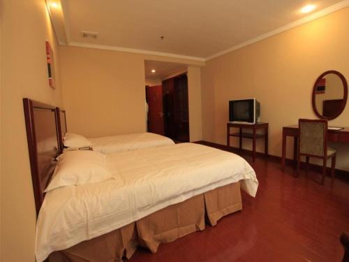 a hotel room with a bed and a television at GreenTree Inn Yangzhou Slender West Lake South Gate Express Hotel in Yangzhou