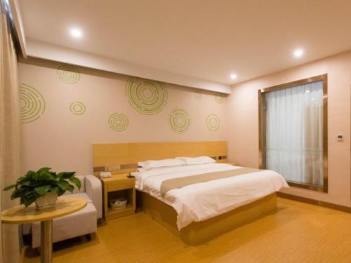 een slaapkamer met een bed, een tafel en een raam bij GreenTree Inn Xingtai City Neiqiu County 107 National Road Business Hotel in Xingtai