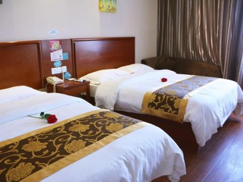pokój hotelowy z 2 łóżkami z białą pościelą w obiekcie GreenTree Inn Fuyang Shopping Mall w mieście Guoyang