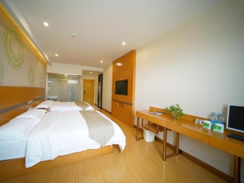 a bedroom with a large white bed and a desk at GreenTree Inn ShanghaiBaoshan District Tieshan Road Youyi Road Hotel in Baoshan