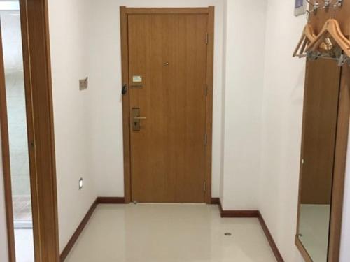 a hallway with a wooden door in a room at GreenTree Inn Nanjing Jiangning District Jiulong Lake Subway Station Express Hotel in Jiangning