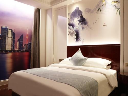a bedroom with a bed with a view of a city at GreenTree Eastern Yancheng Jianhu County Aobaolia Life Plaza Hotel in Yancheng