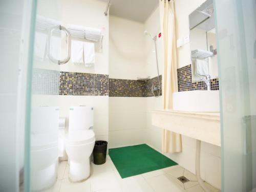 a bathroom with a toilet and a sink and a mirror at Shell Binzhou Bincheng District Yellow River Four Road Hotel in Binzhou